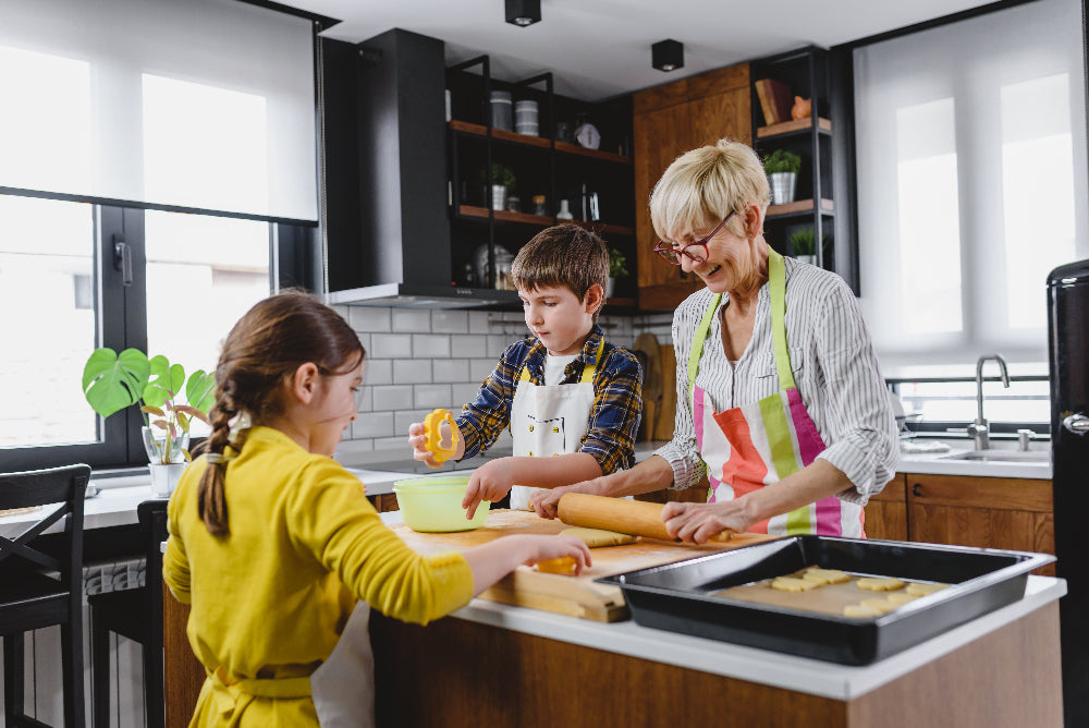 Woman and two children in a kitchen baking together.