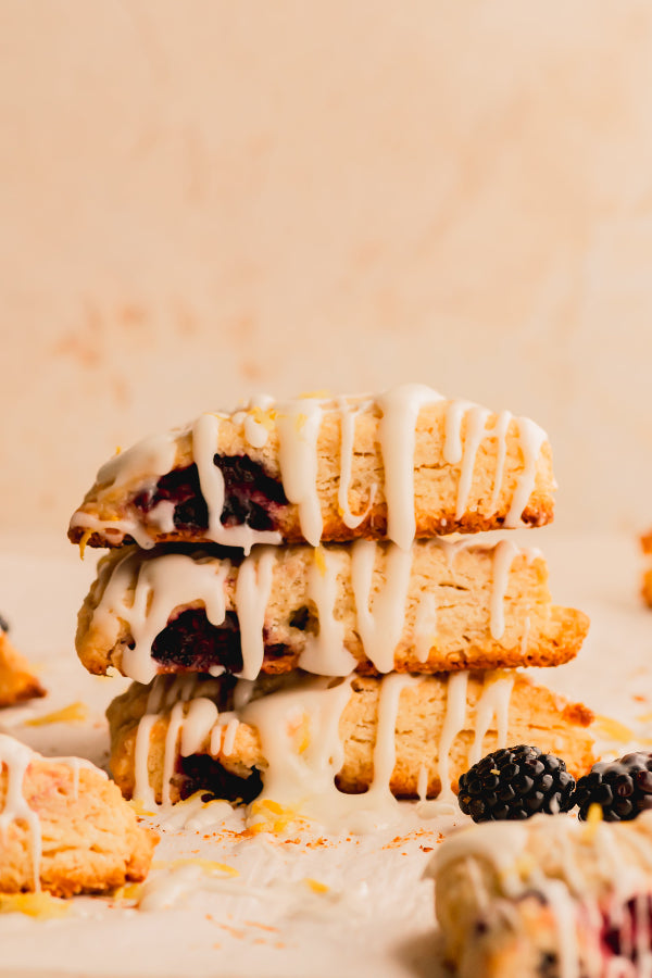 Stack of berry-filled pastries with white glaze on a light background