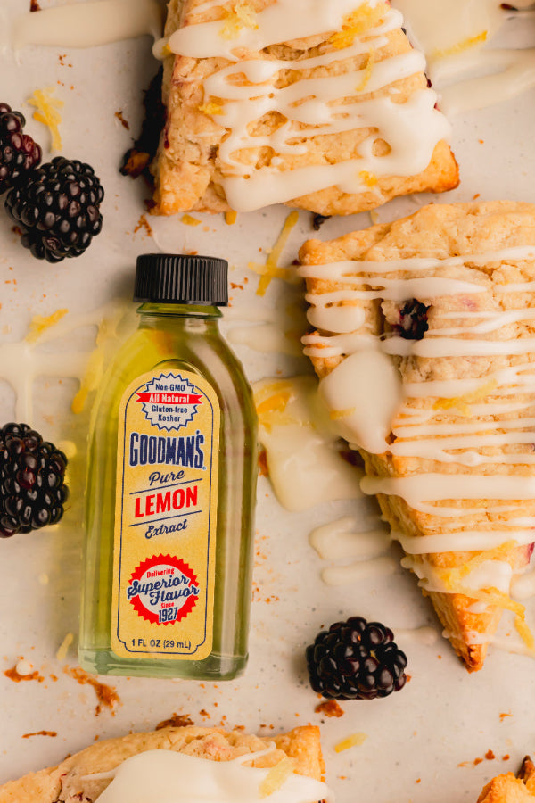 Goodman's Pure Lemon Extract bottle with scones and blackberries on a light surface