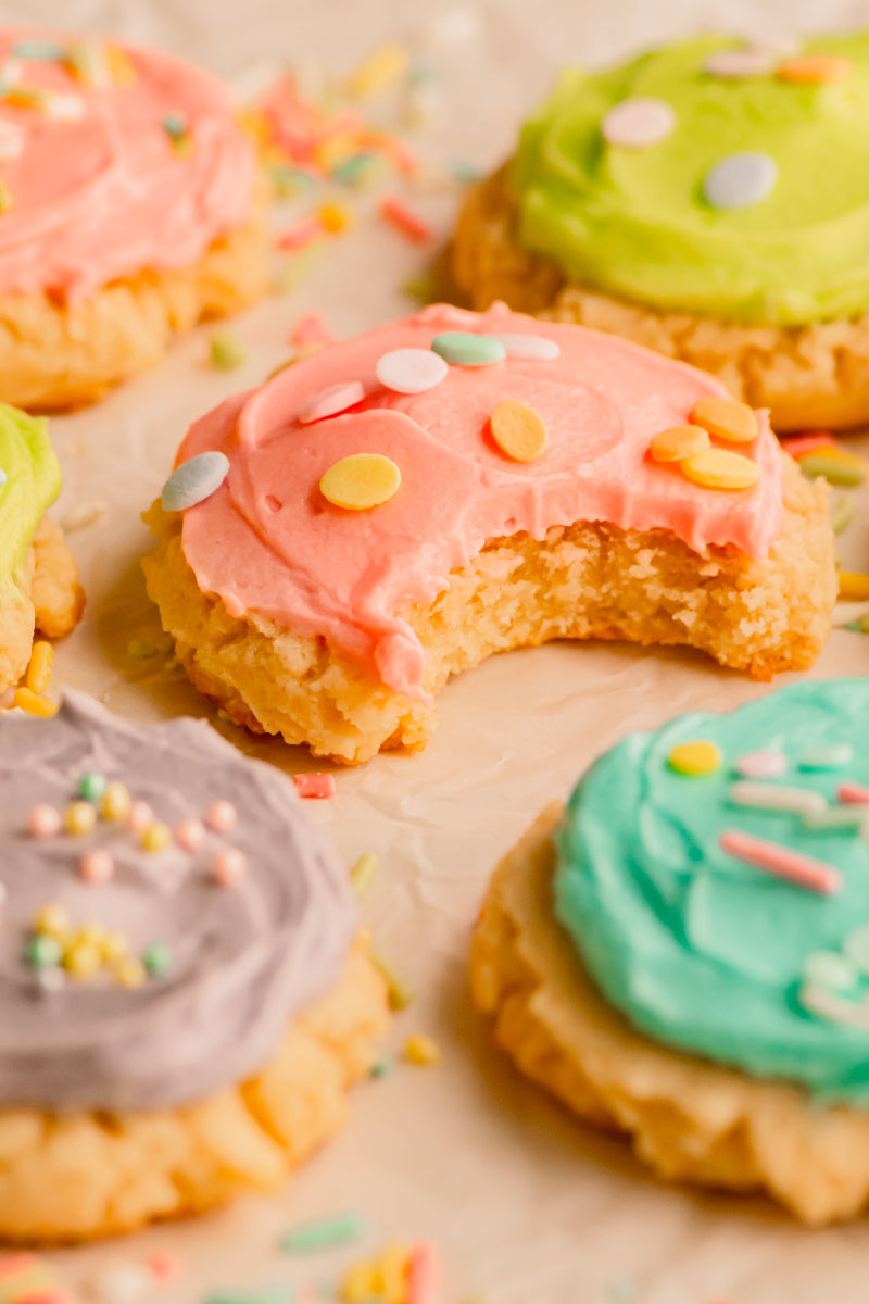 Colorful frosted cookies with sprinkles on a light background