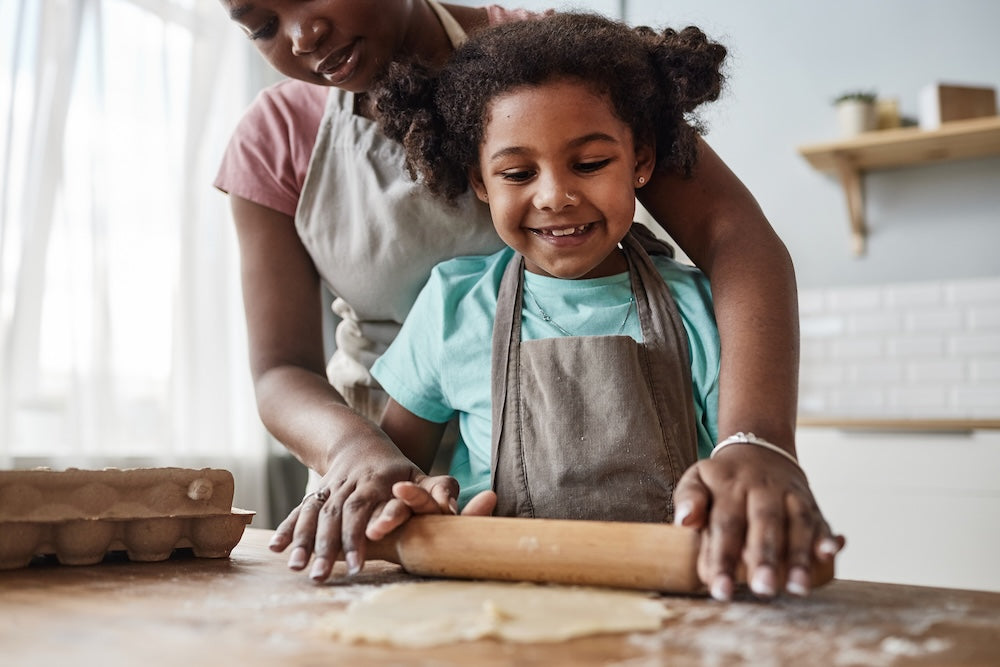 Loving_mother_and_daughter_baking_together_at_home_and_rolling_dough