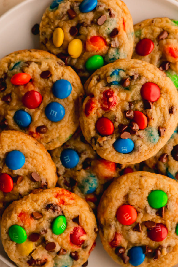 Cookies with colorful M&M candies on a white plate